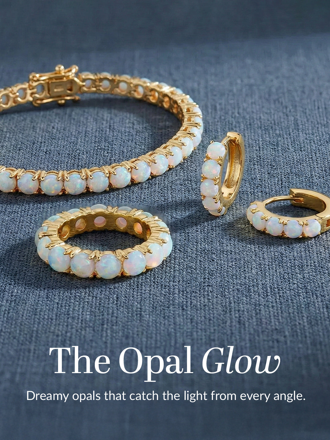 Gold jewelry set with opal stones on a blue fabric background