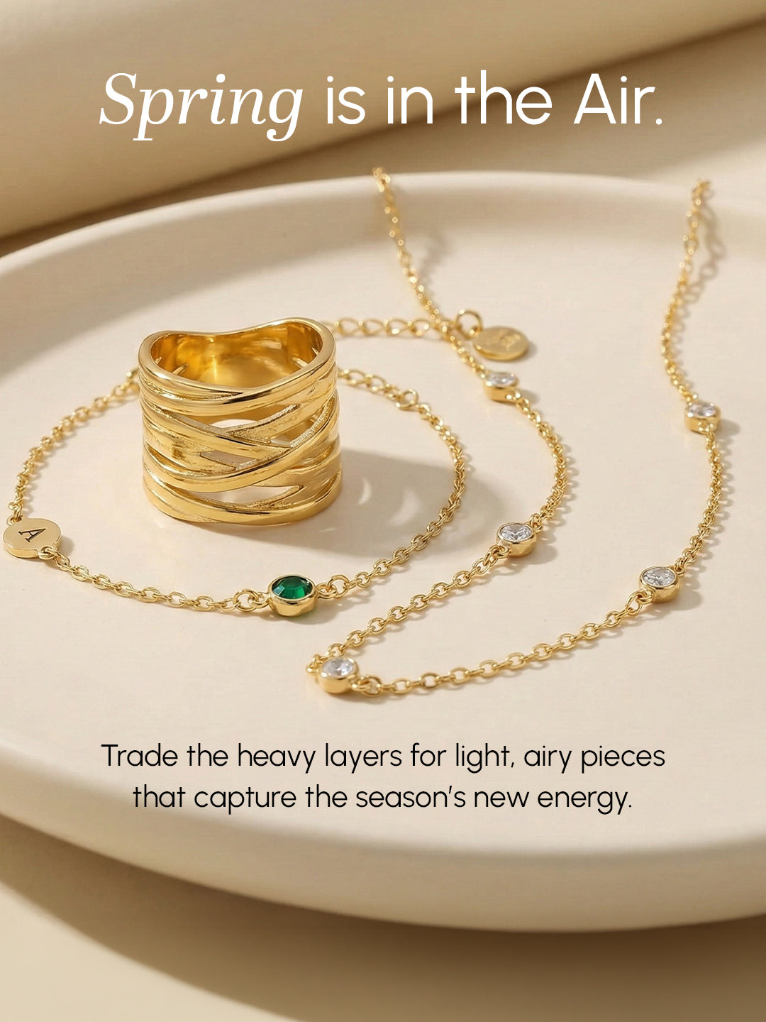Gold jewelry set including a ring and necklace on a beige surface with text about spring.