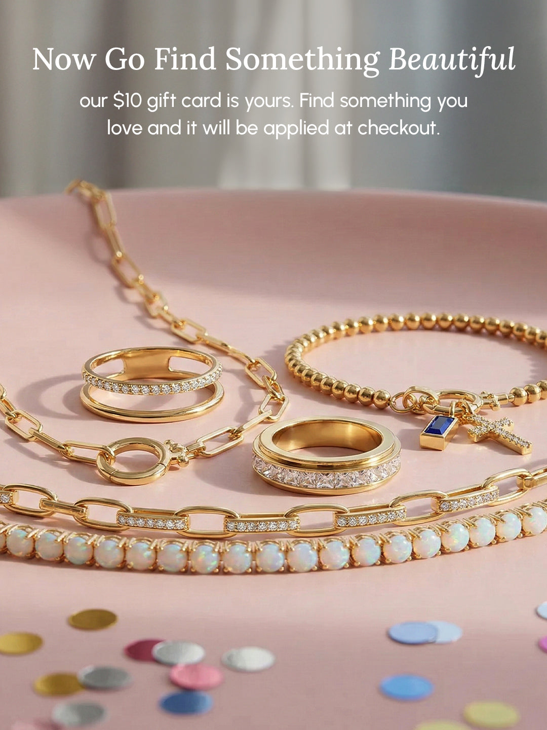 Gold jewelry set with rings and chains on a pink surface, promotional text overlay.