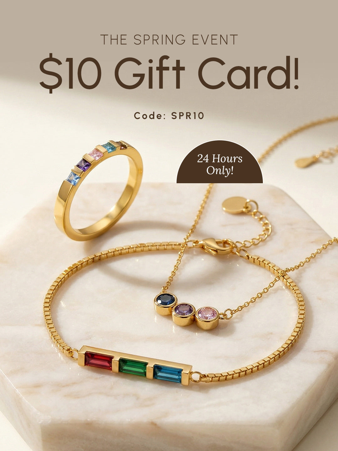 Gold ring and matching bracelet with colorful gemstones displayed on a marble surface, with text “$10 Gift Card,” “The Spring Event,” “24 Hours Only,” and code “SPR10.”