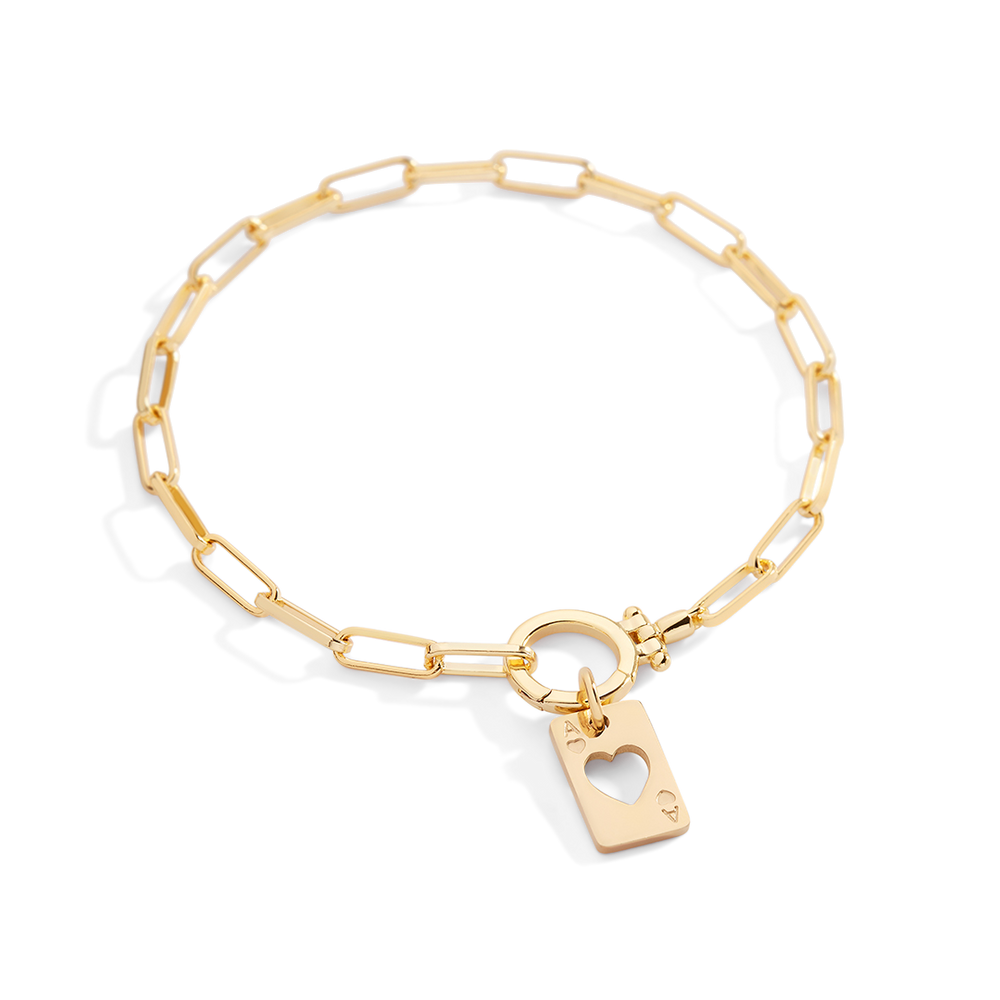 Gold bracelet with a heart-shaped tag on a light gray background