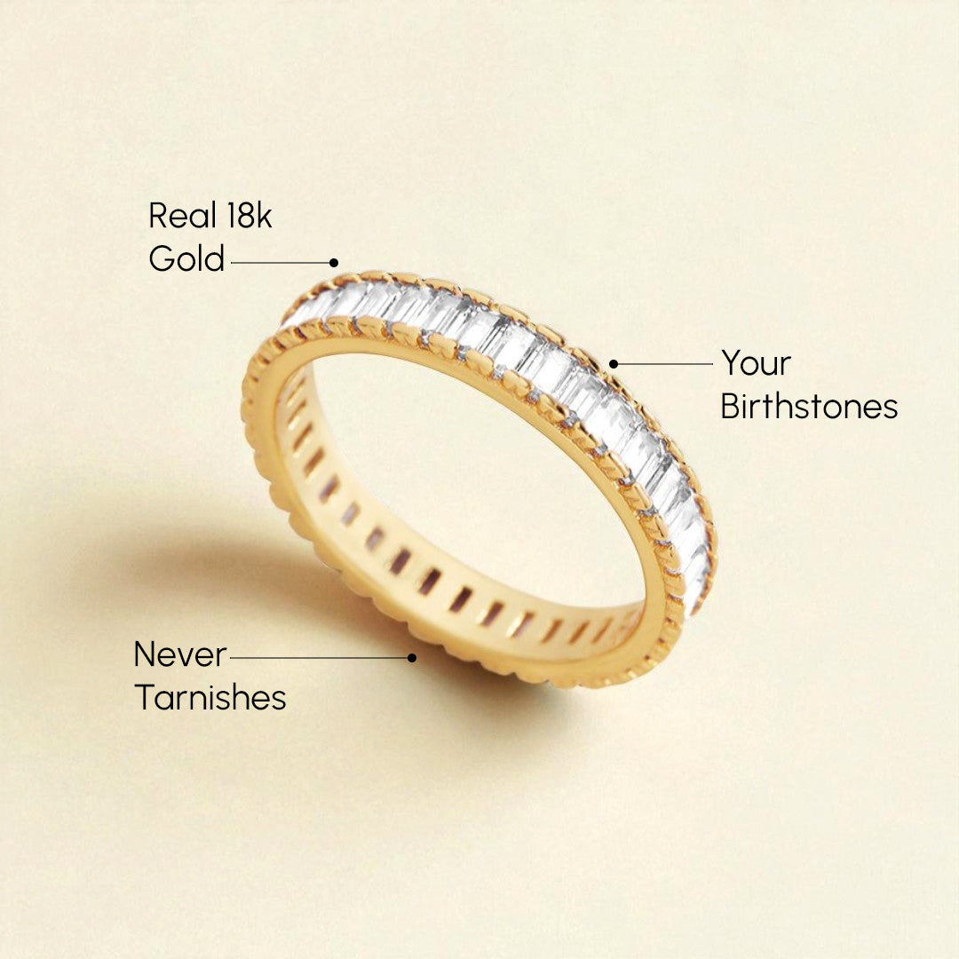 Gold ring with baguette-cut gemstones on a beige background