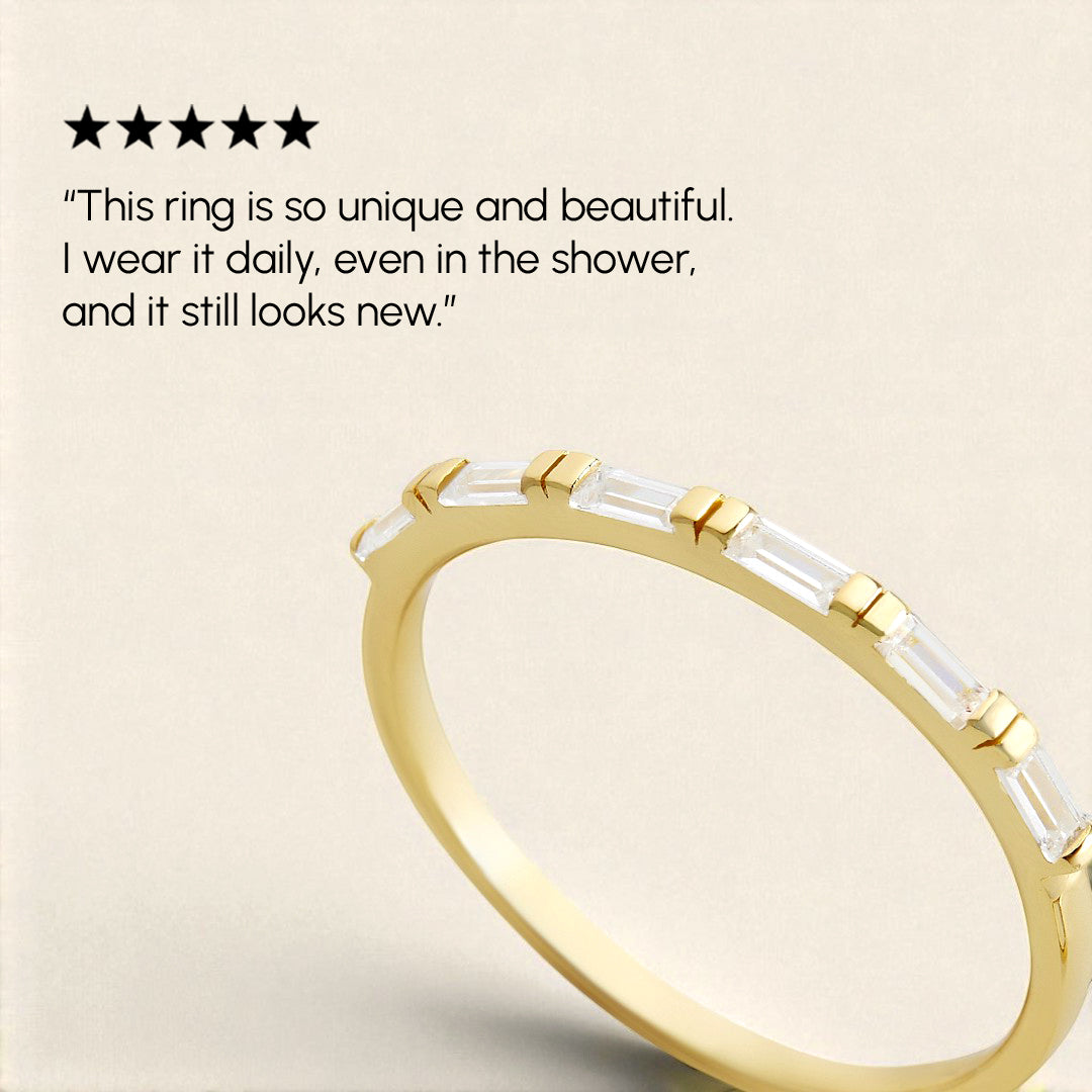 Gold ring with clear gemstones on a beige background, featuring a five-star rating and customer review.