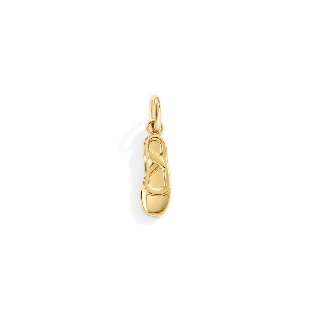 Gold ballet slipper charm on a white background