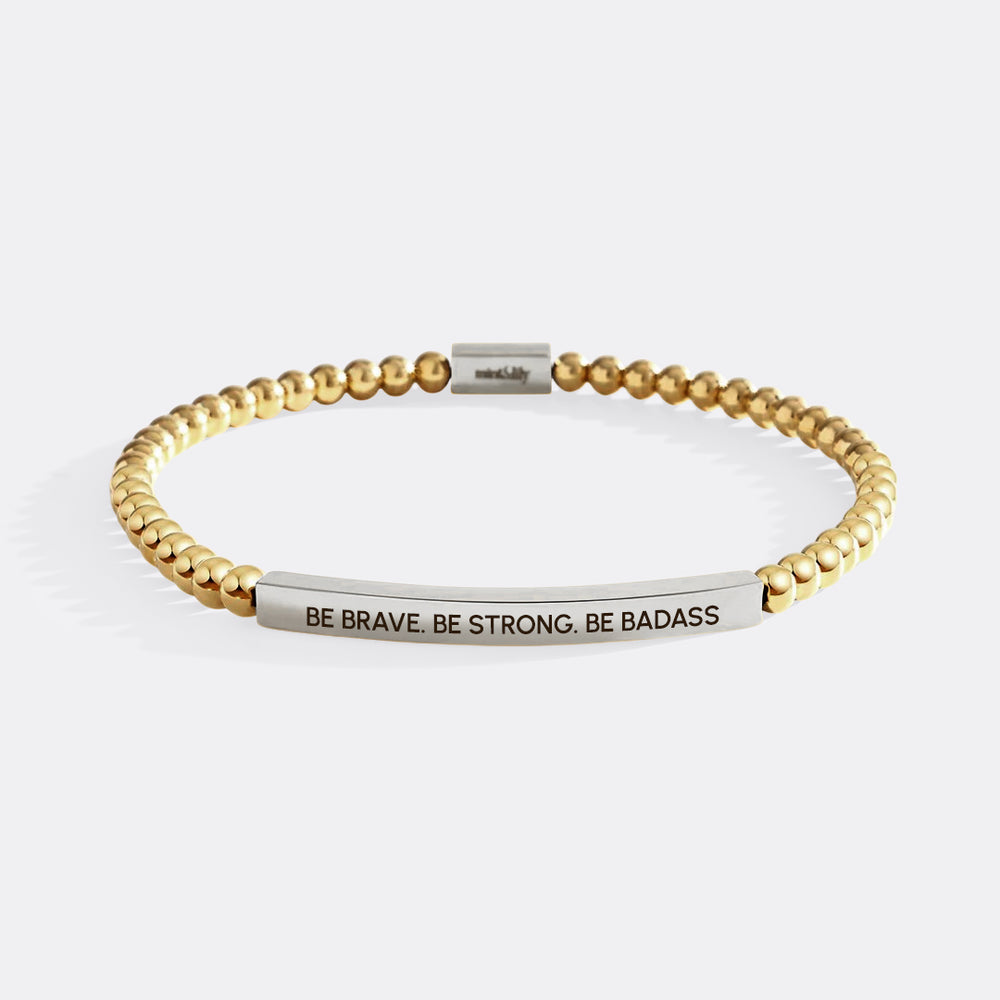 Gold and silver beaded bracelet with motivational message on a white background