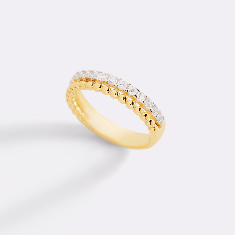 Gold ring with embedded diamonds on a light gray background