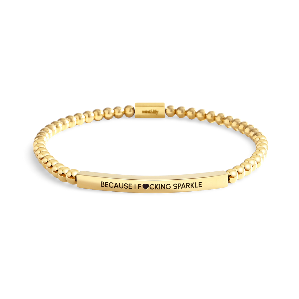 Gold beaded bracelet with engraved text on a white background
