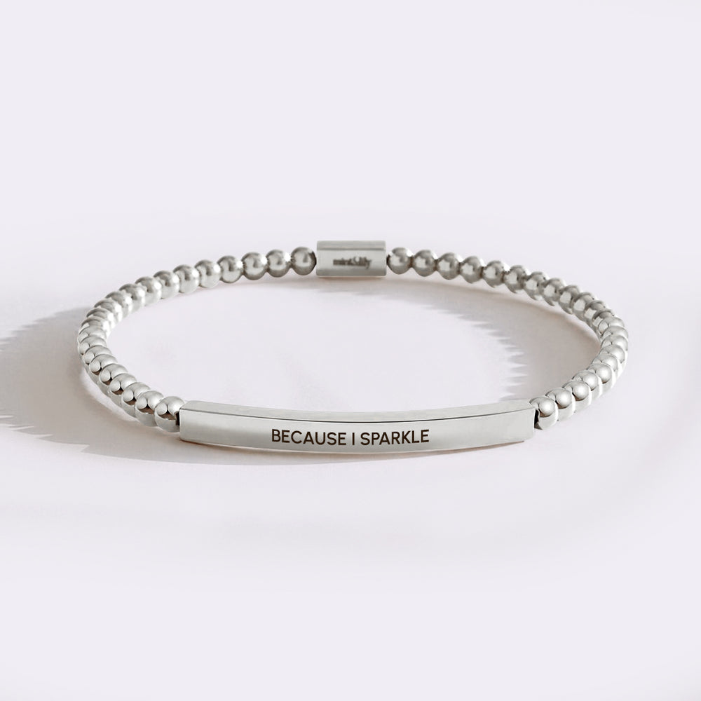 Silver beaded bracelet with engraved message on a white background