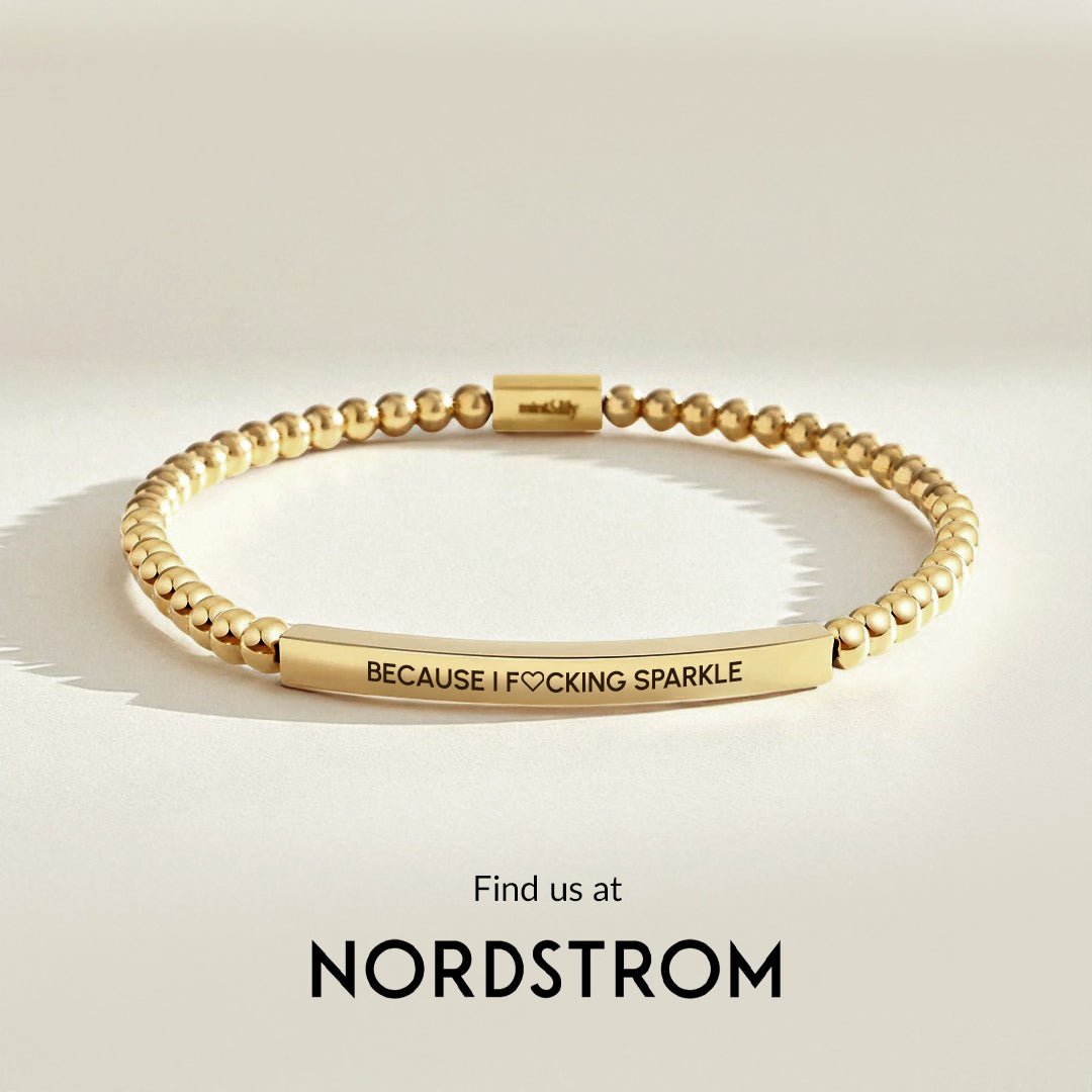Gold bracelet with engraved message on a light beige background, Nordstrom branding visible.
