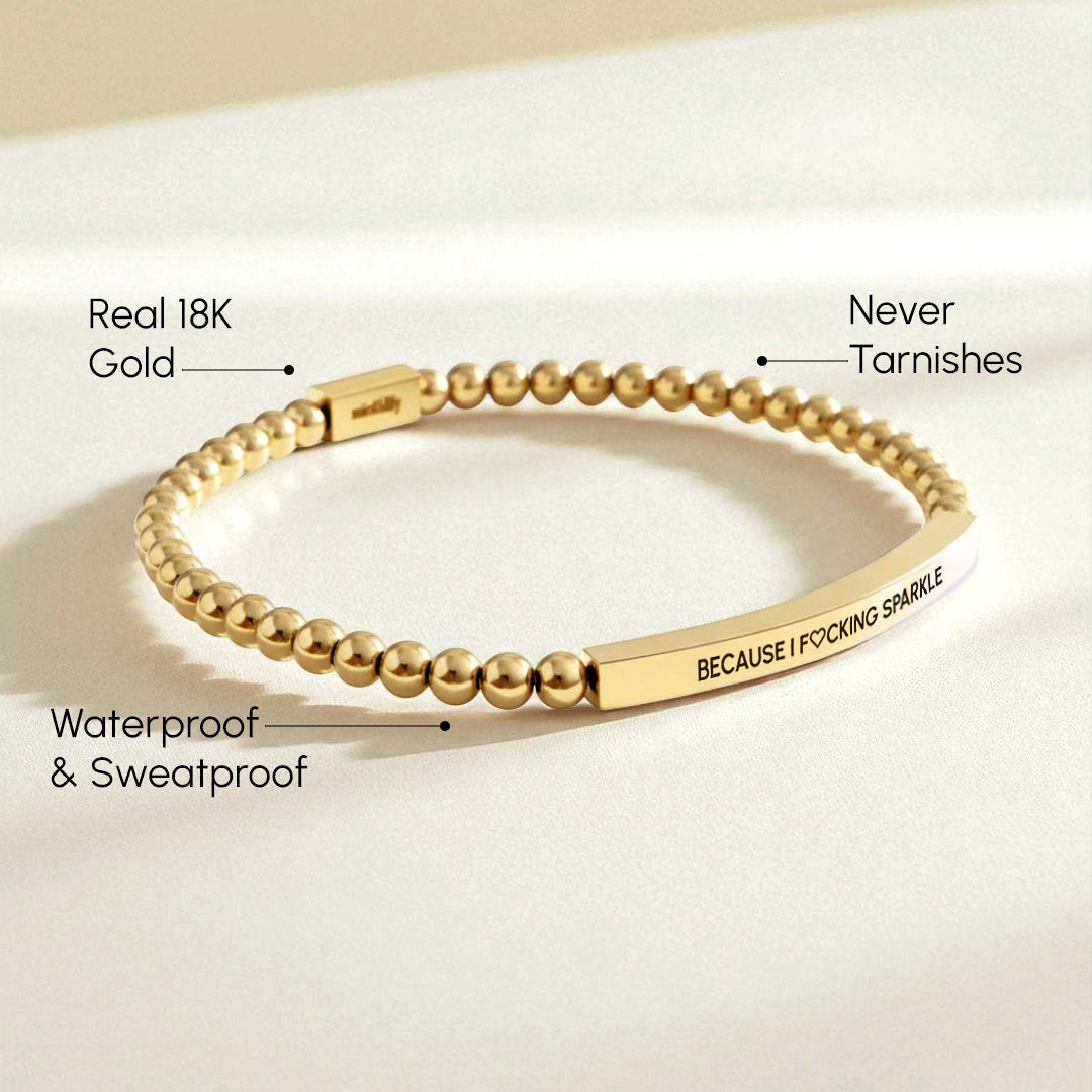 Gold bracelet with text on a beige background