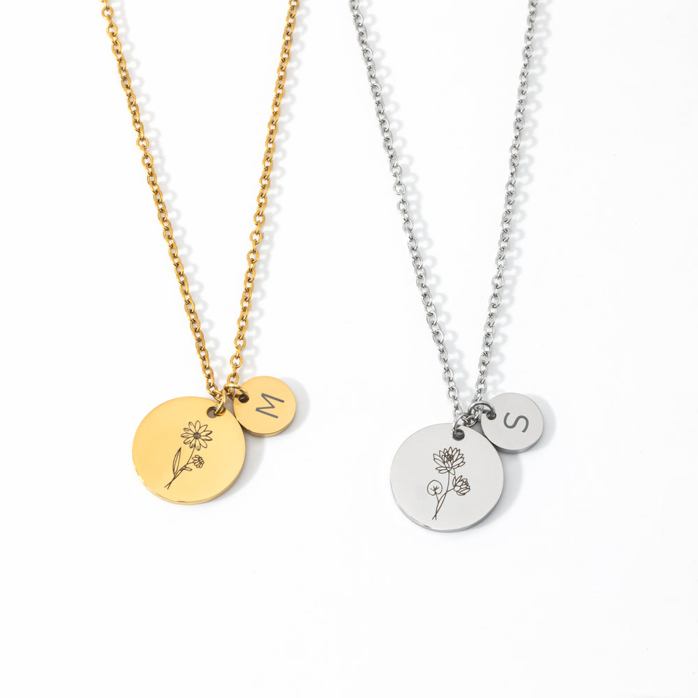 Flat lay of Birth Flower Initial Necklaces showing several engraved flower discs paired with initial discs.