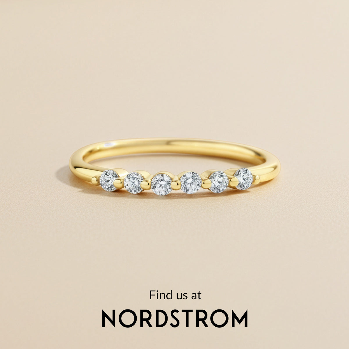 Gold ring with diamonds on a beige background, Nordstrom branding visible.