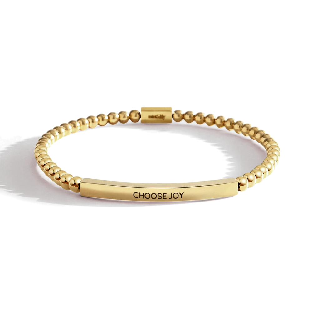Gold bracelet with 'CHOOSE JOY' engraving on a white background