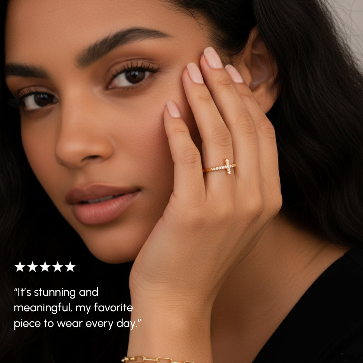 Woman wearing a gold ring with a cross design, close-up of face and hand.