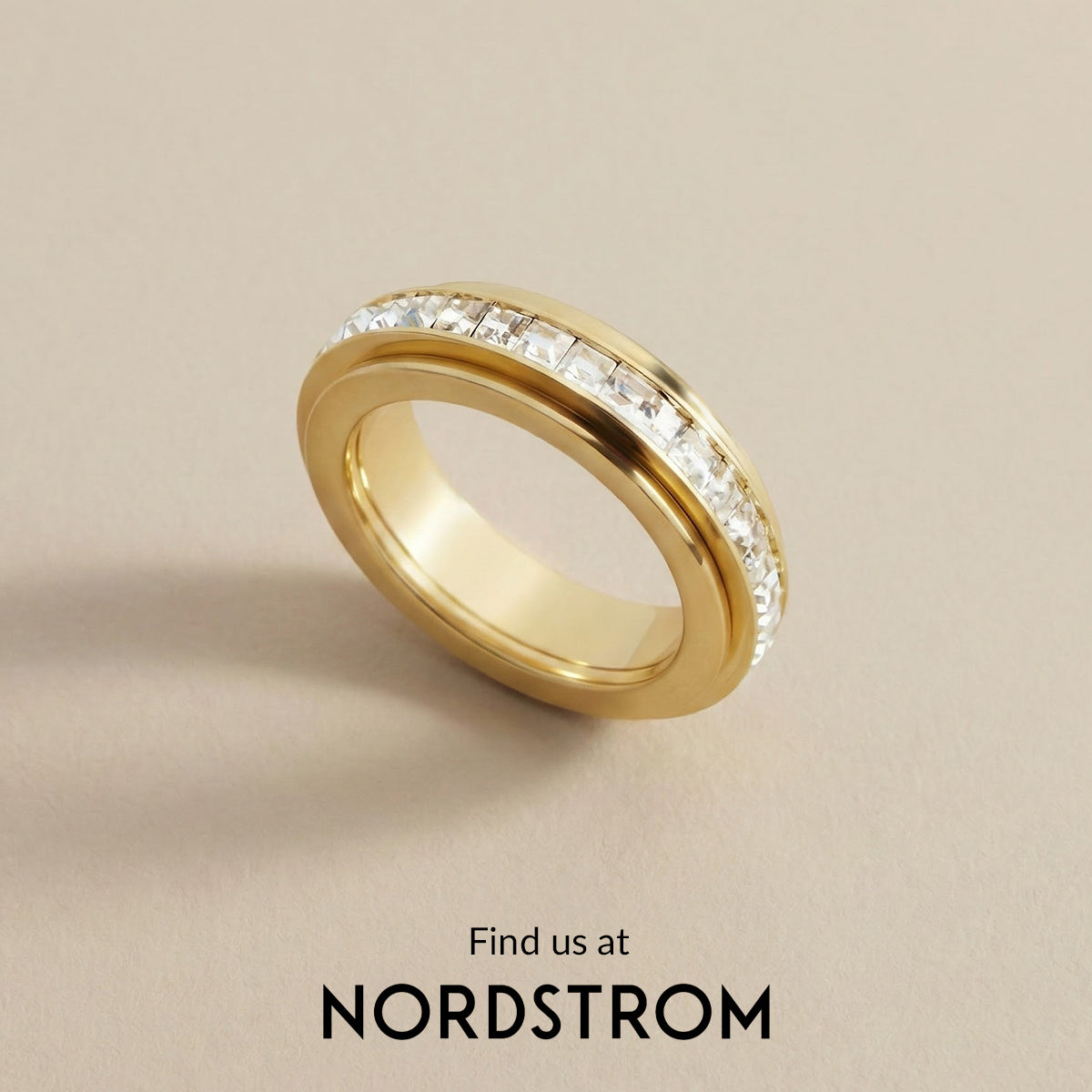 Gold ring with diamonds on a beige background, Nordstrom branding visible