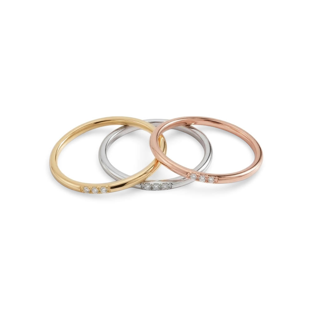 Three gold, silver, and rose gold bangles on a light gray background