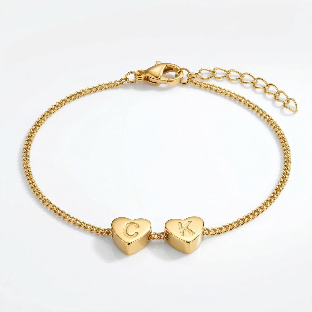 Gold bracelet with heart-shaped charms on a white background