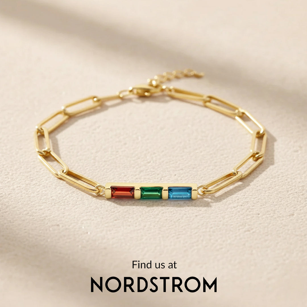 Gold bracelet with colorful stones on a beige background, Nordstrom branding visible.