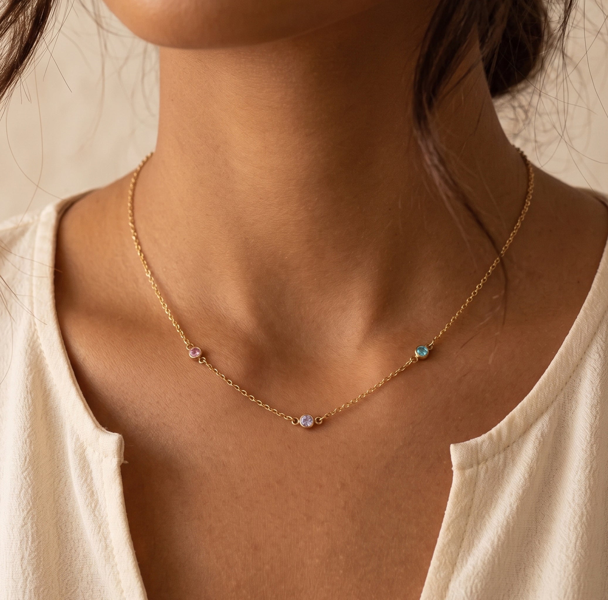 Necklace with small beads worn by a person against a neutral background