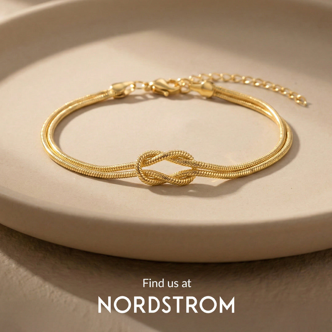 Gold bracelet with a knot design on a beige plate, Nordstrom branding visible.
