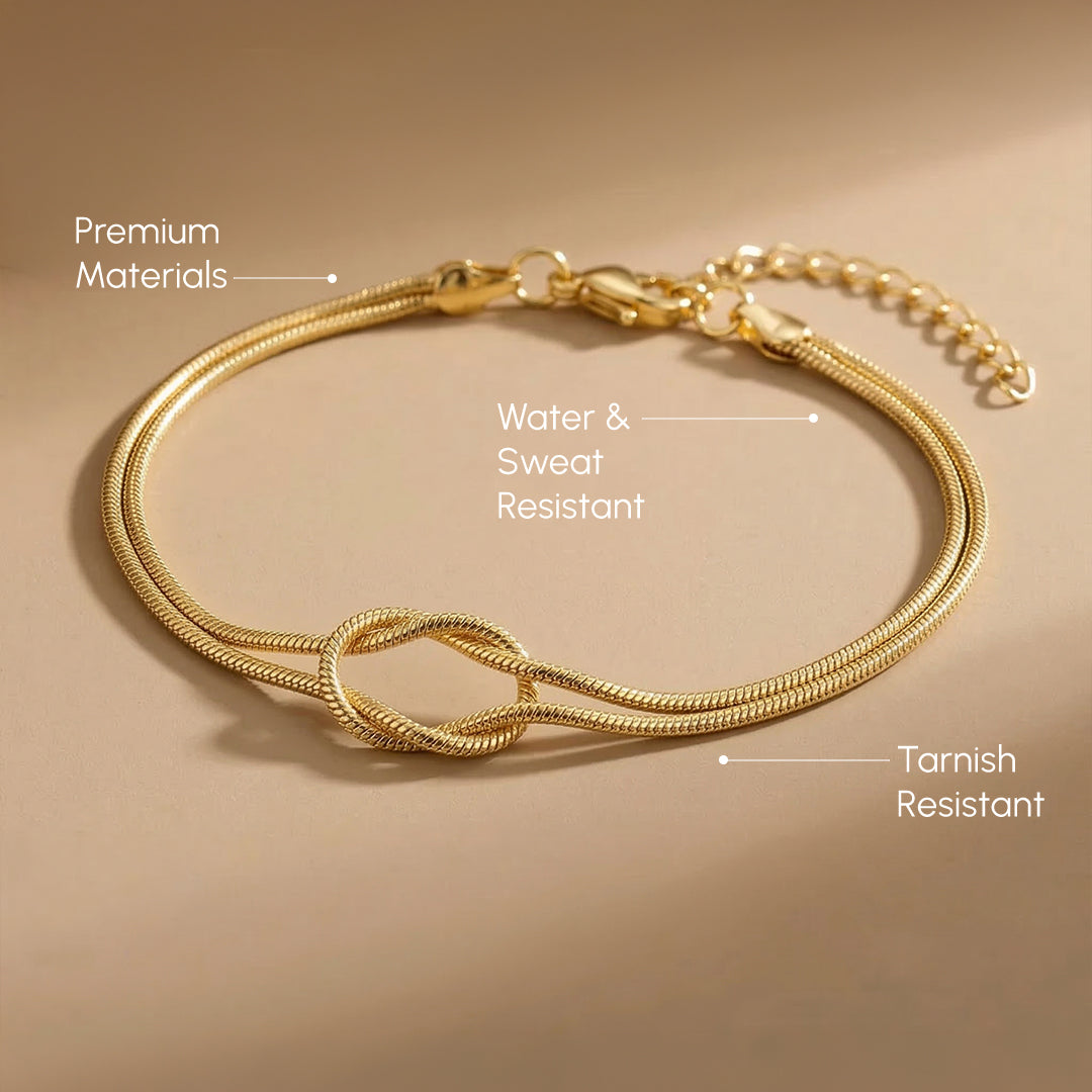 Gold bracelet with knot design on a beige surface, labeled for material and feature points.