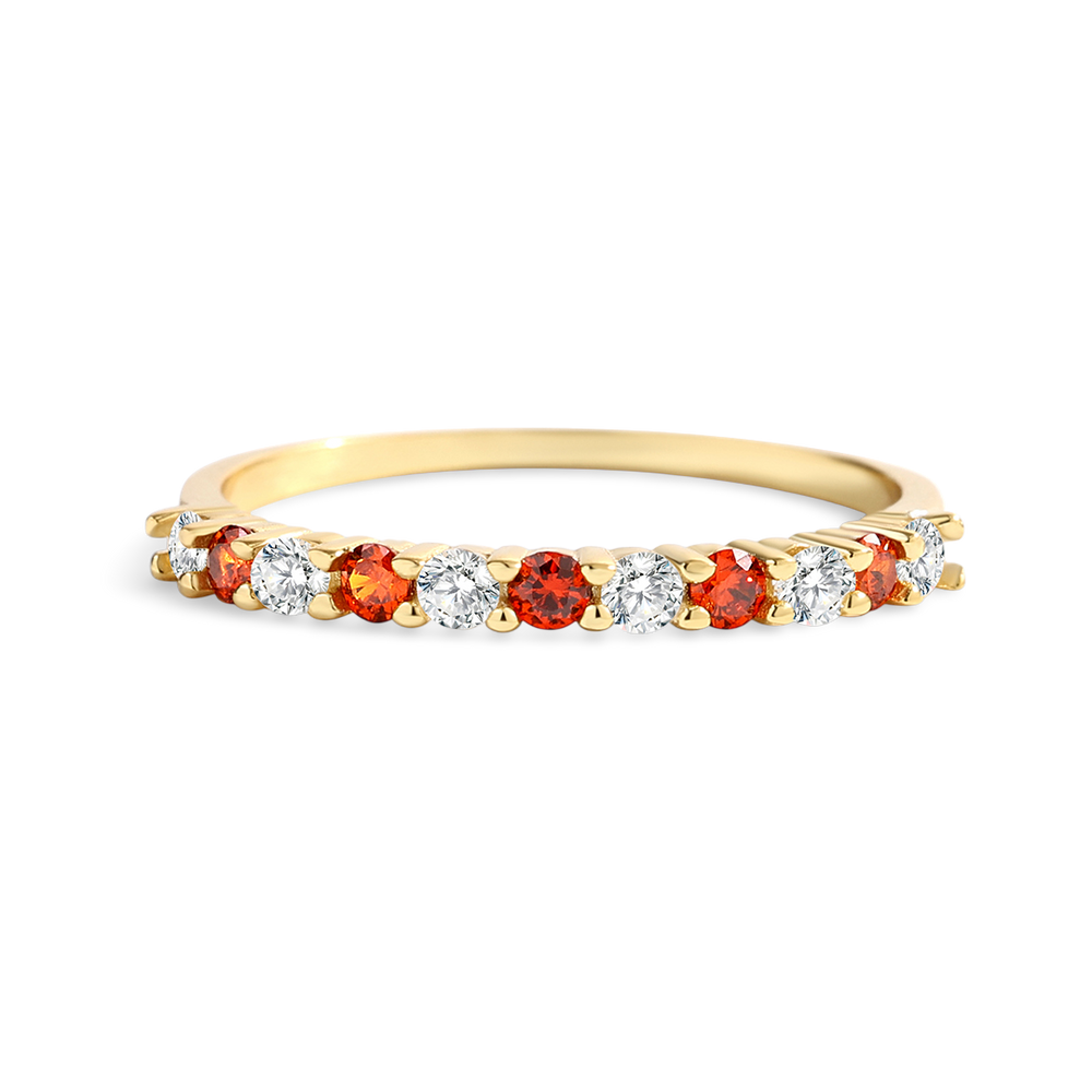 Gold ring with red and white gemstones on a light gray background