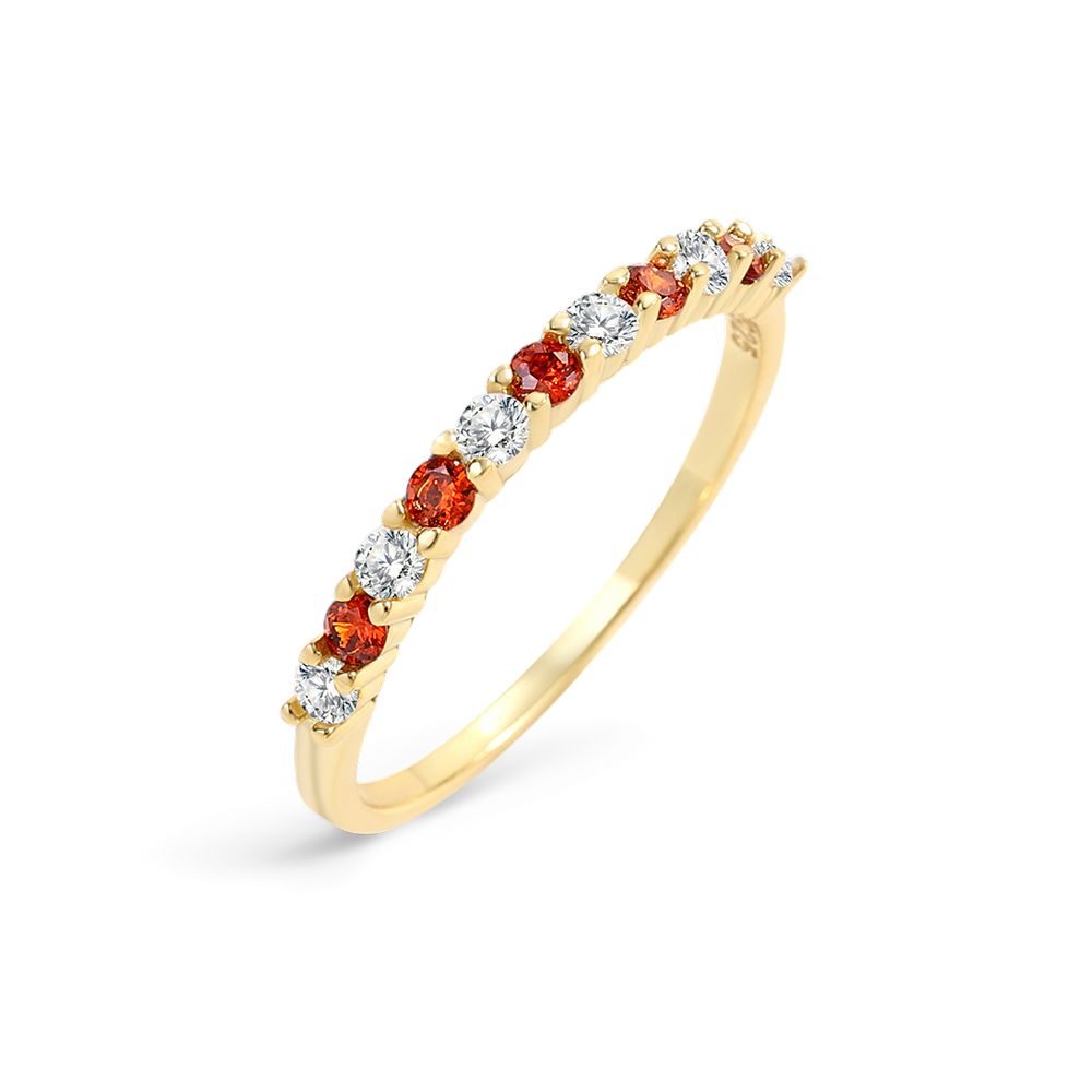 Gold ring with red and clear gemstones on a light gray background