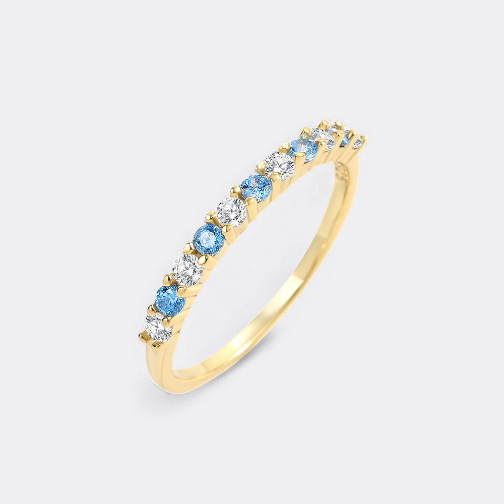 Gold ring with blue and clear gemstones on a white background