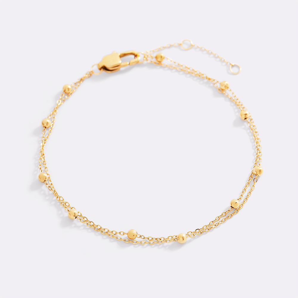 Gold bracelet on a light gray background