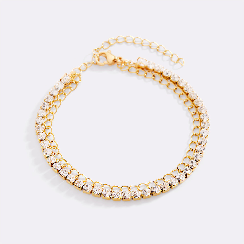 Gold bracelet with clear gemstones on a light gray background