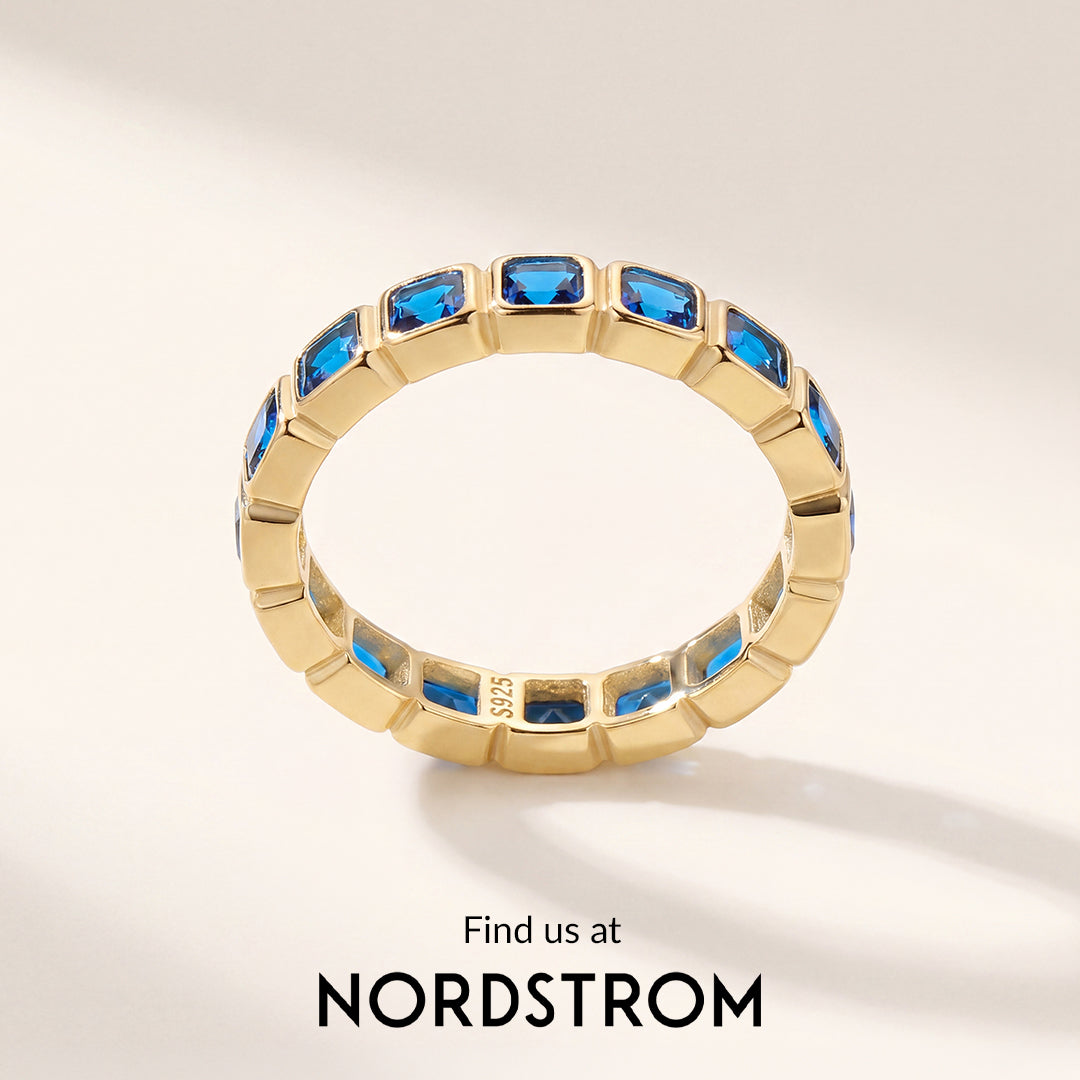 Gold ring with blue gemstones on a light background, featuring Nordstrom branding.