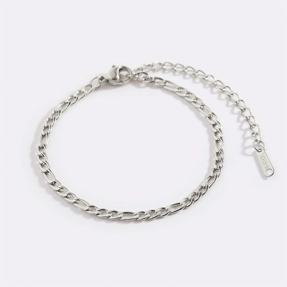 A gold-colored Figaro chain bracelet with a sleek, interwoven link design.