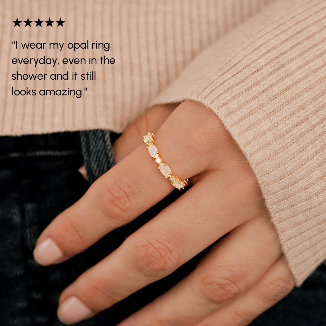 Hand wearing an opal ring with a five-star rating text overlay.