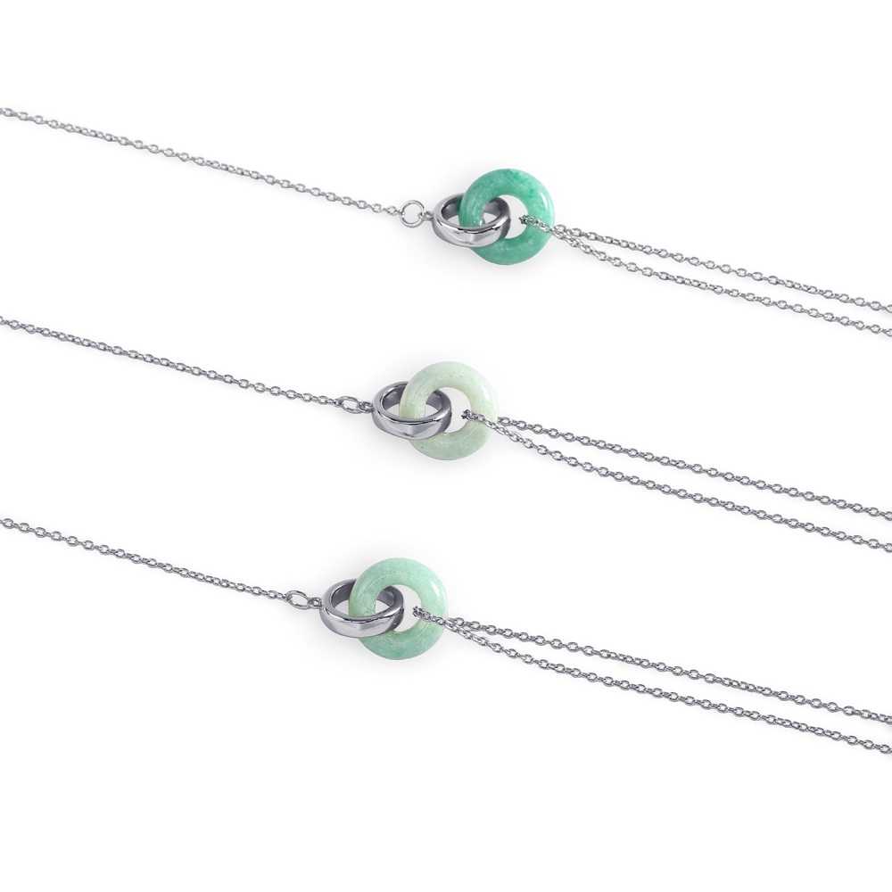 Three silver necklaces with green beads on a white background