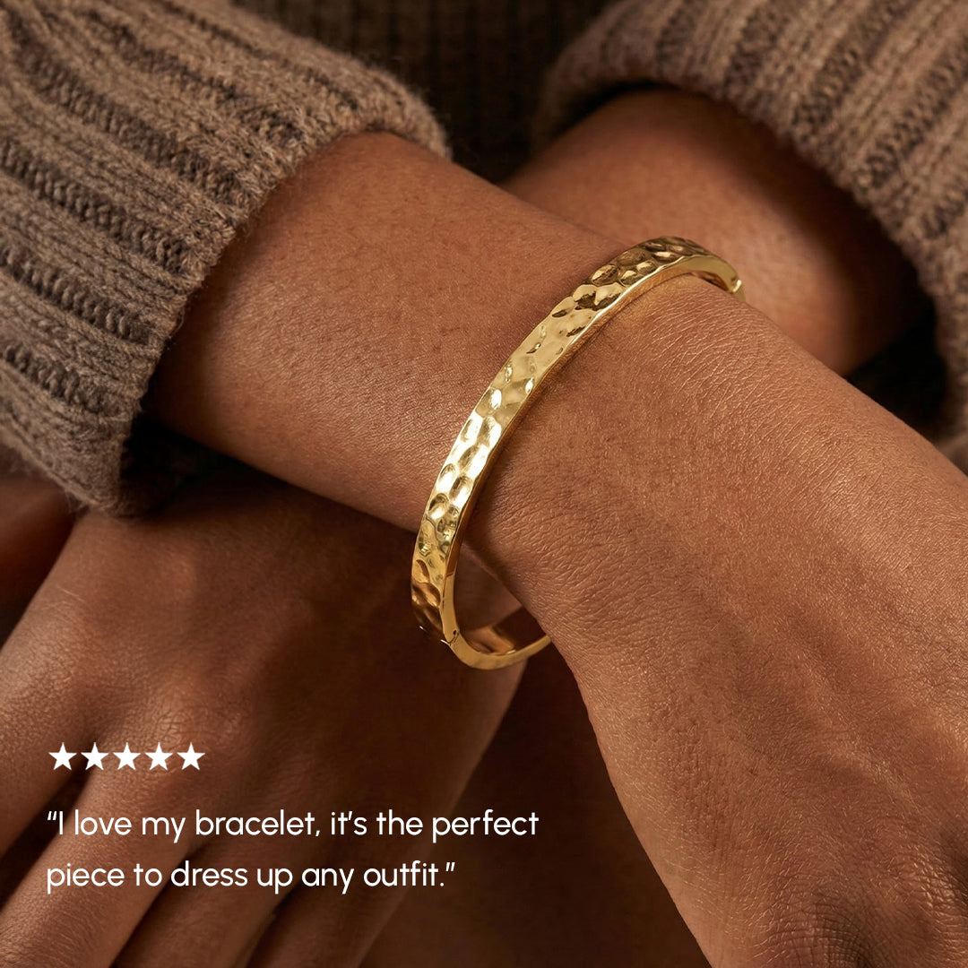 Gold bracelet on a wrist with a five-star rating and customer review text.