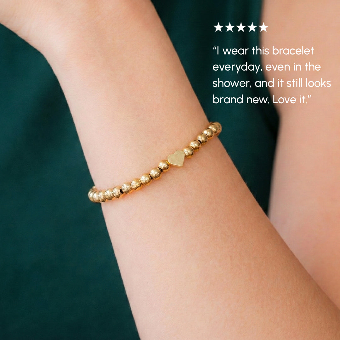 Gold bracelet on a wrist with a green background and customer review text.