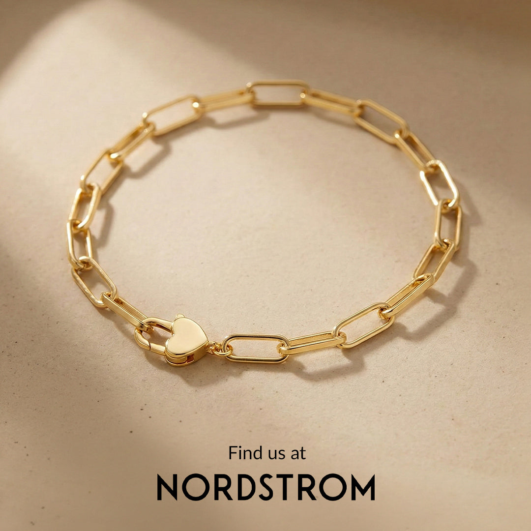 Gold chain bracelet with heart clasp on a beige background, Nordstrom branding visible.