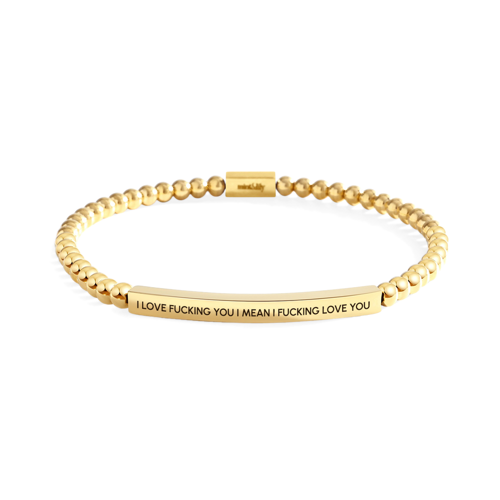 Gold beaded bracelet with engraved message on a white background