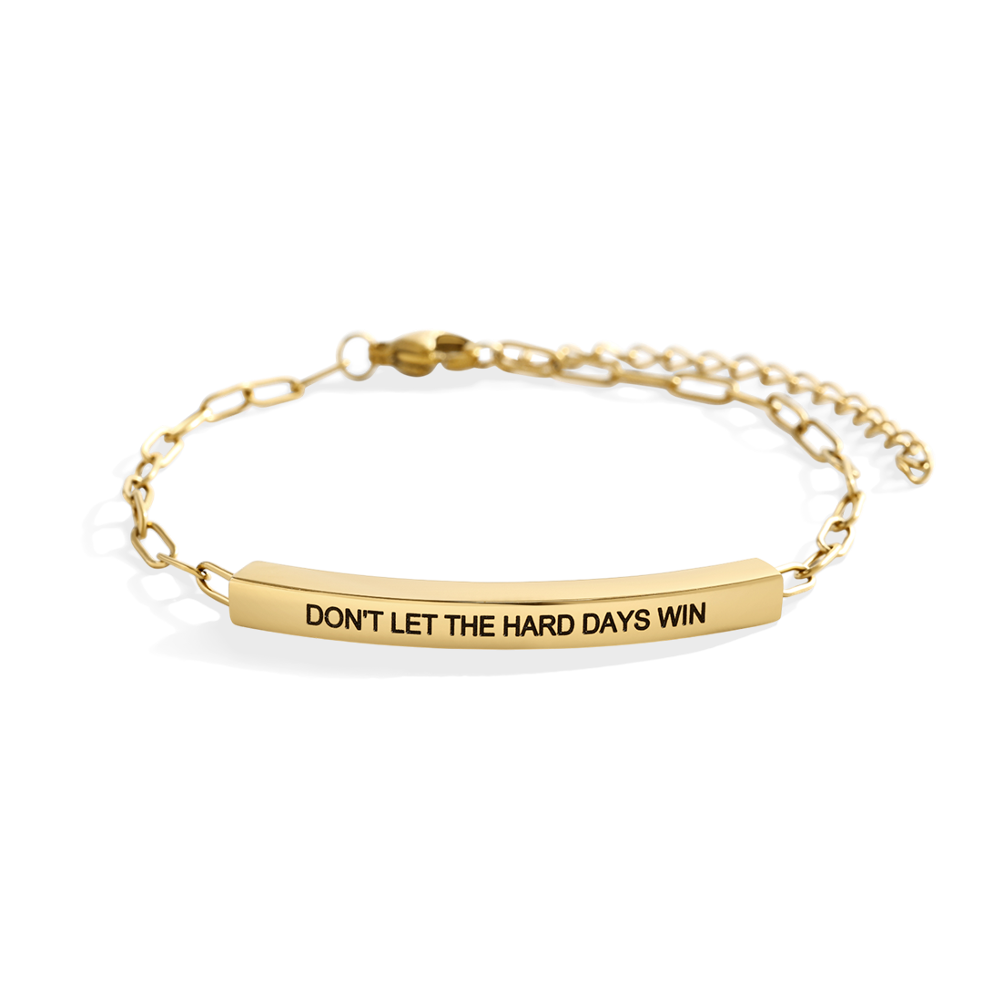 Gold bracelet with motivational message on a white background