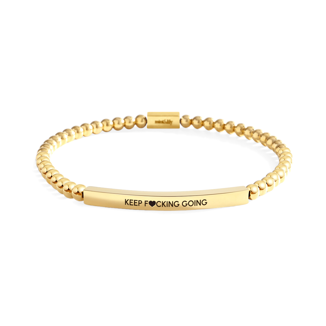 Gold bracelet with engraved message on a white background