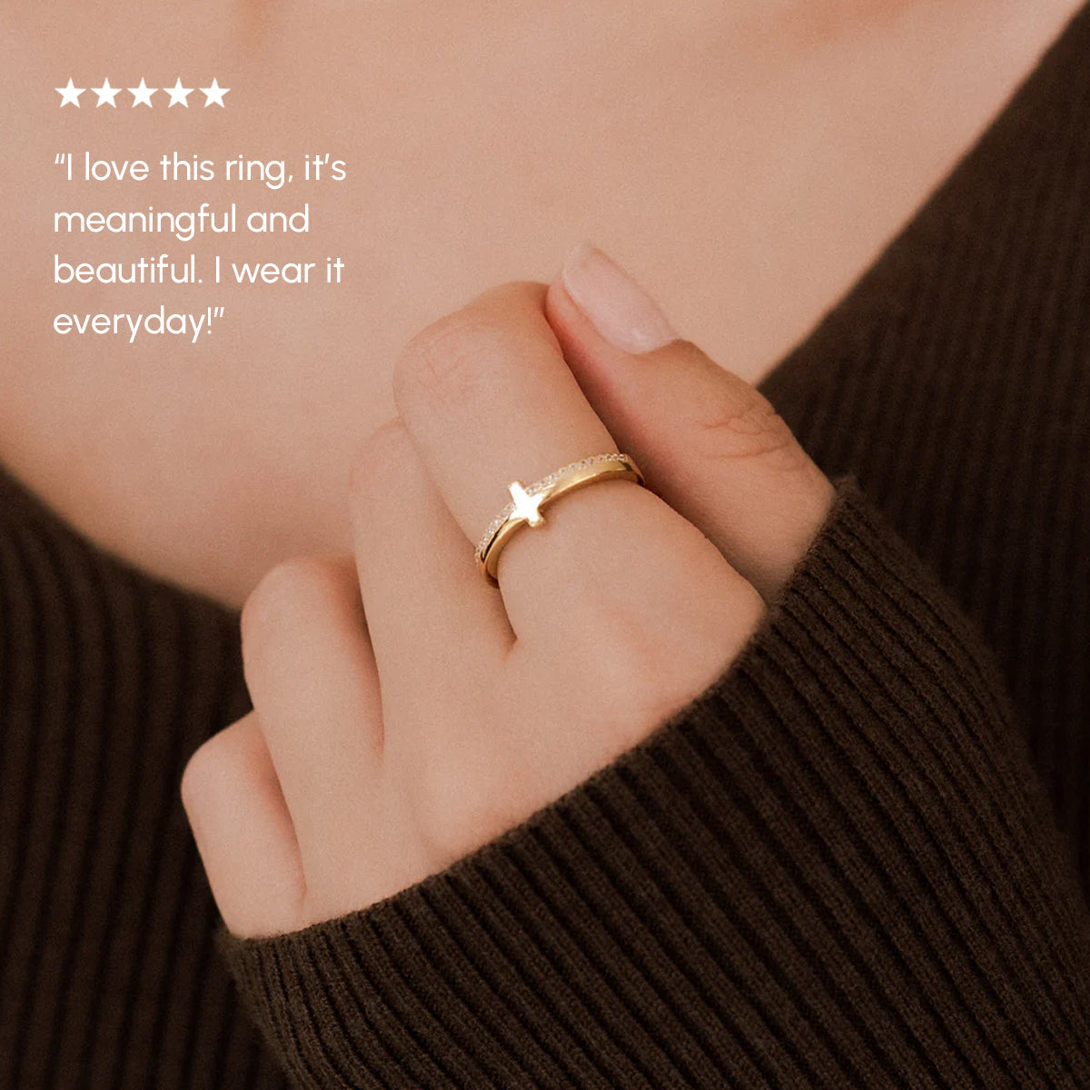 Hand wearing a gold ring with a star design, set against a brown textured background.