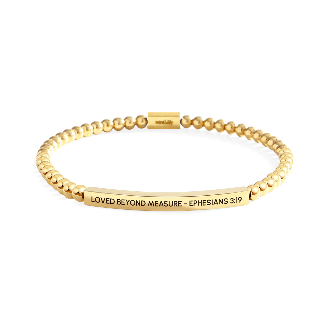 Gold bracelet with engraved text on a white background