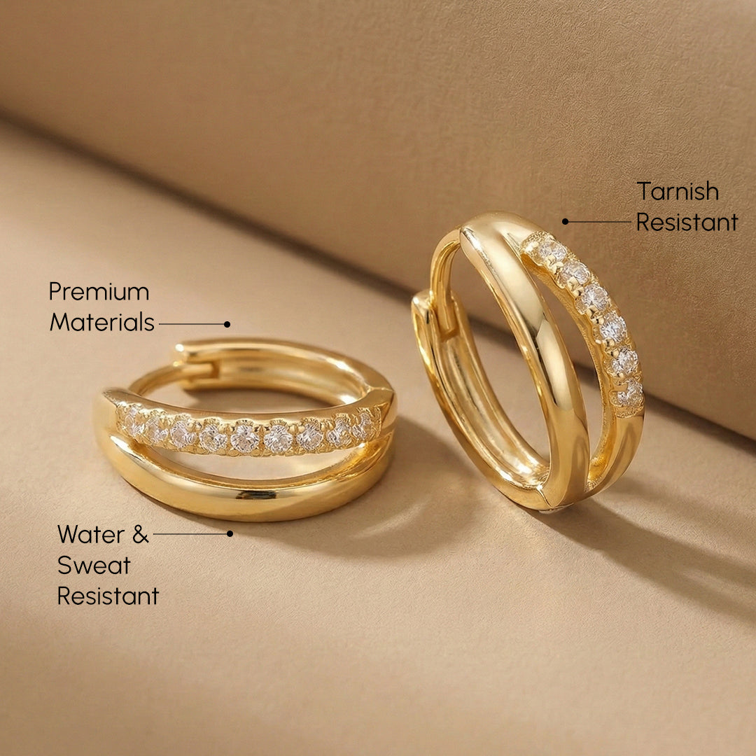 Gold hoop earrings with text highlighting features on a beige background