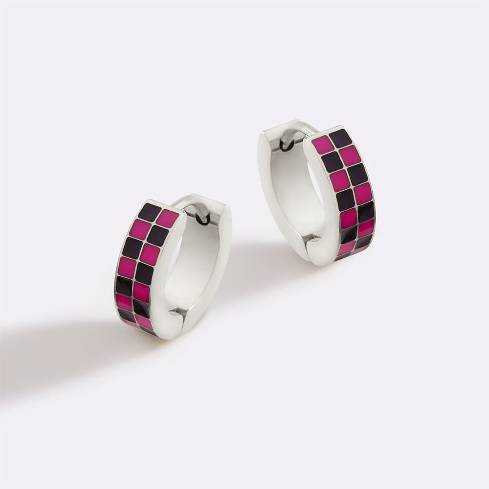 Pair of hoop earrings with pink and black checkered design on a white background