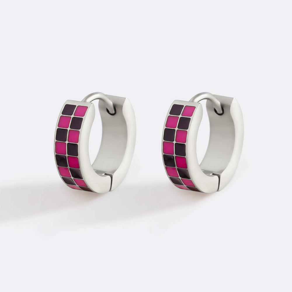 Pair of hoop earrings with pink and black checkered pattern on a white background