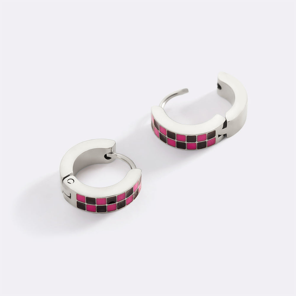 Pair of hoop earrings with pink and black checkered pattern on a white background
