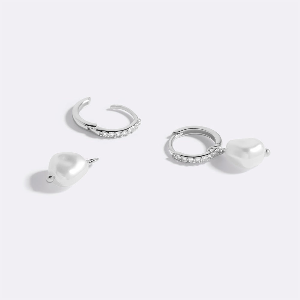 Two pairs of silver hoop earrings with pearls on a white background.