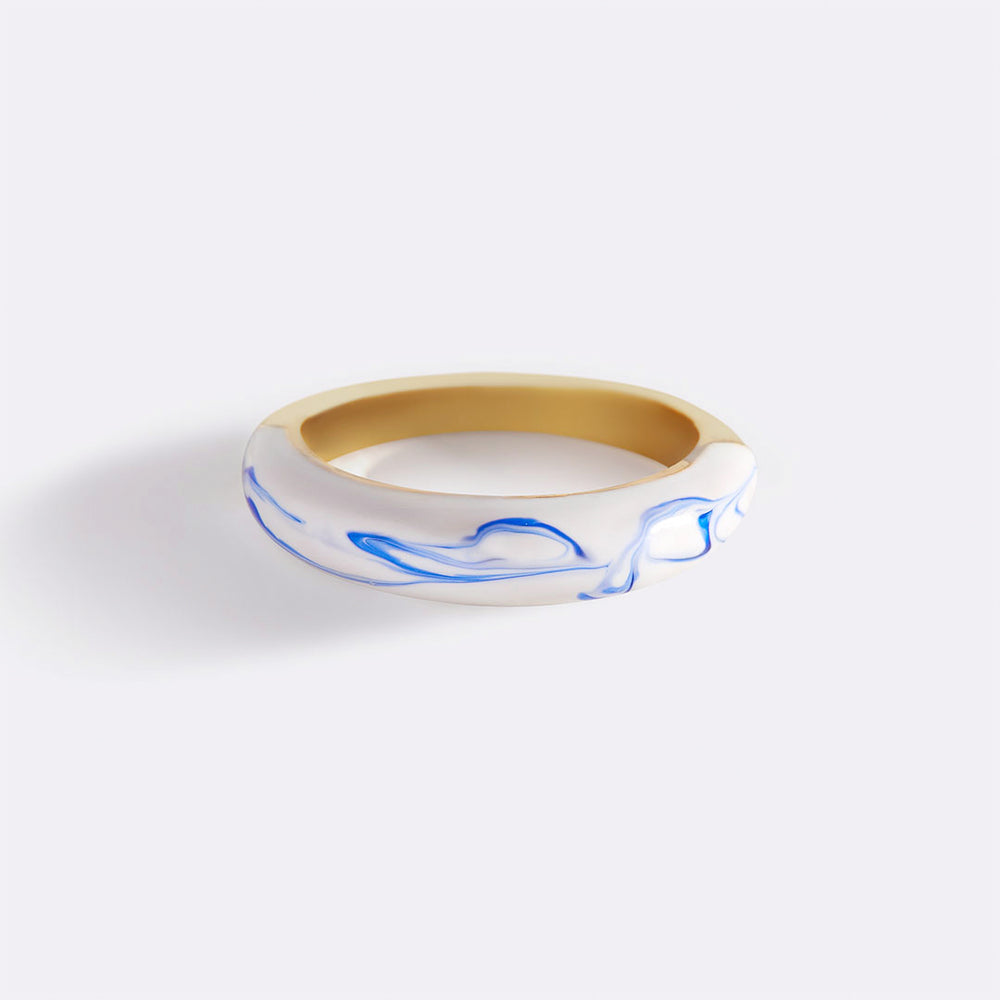 A blue porcelain dome ring with a gold band on a white background.