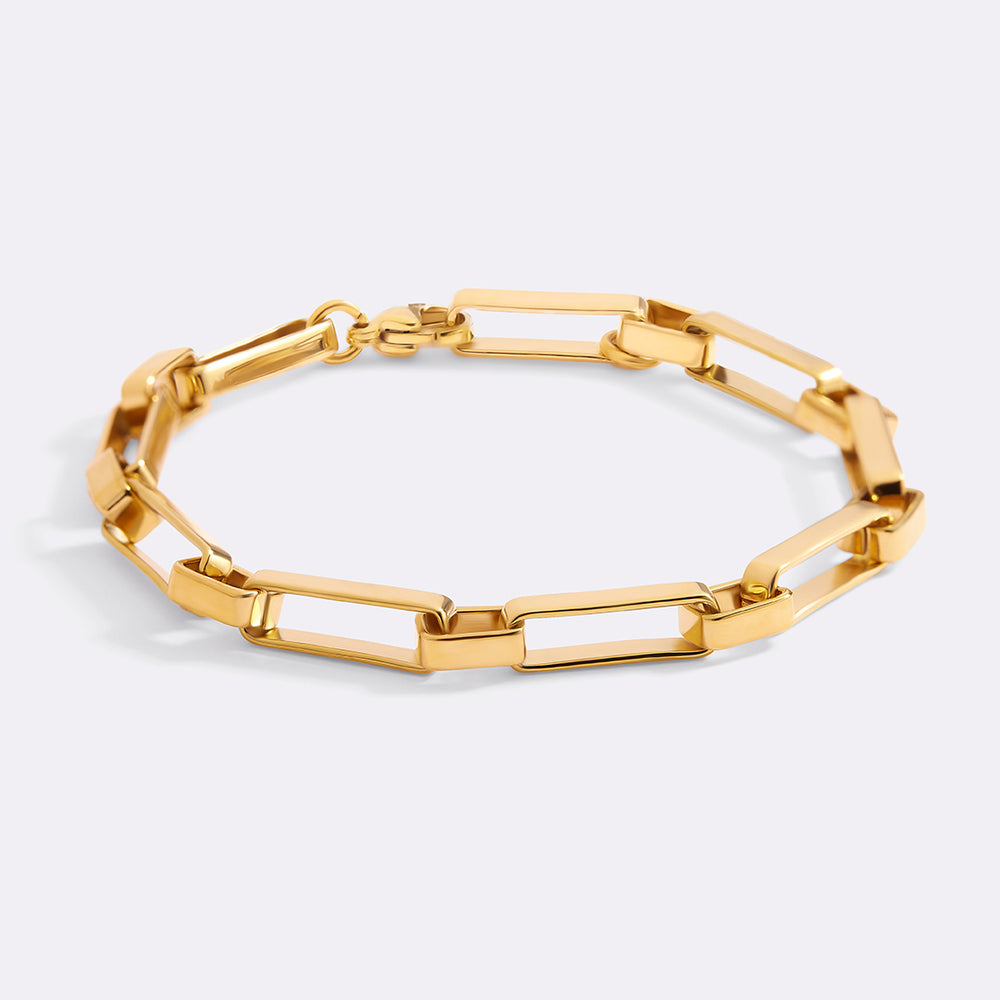 Gold chain bracelet on a light gray background