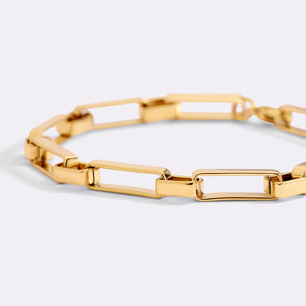 Gold bracelet on a light gray background